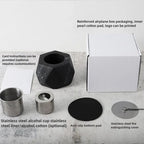 Collection of stainless steel and black alcohol cups with packaging on a white surface.