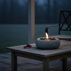 Gaia Tabletop Fireplace on a wooden table by a body of water at night