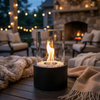 Outdoor patio scene with a helios table-top fire pit, string lights, and cosy furniture.